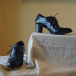 Black brogue patent ankle booties.